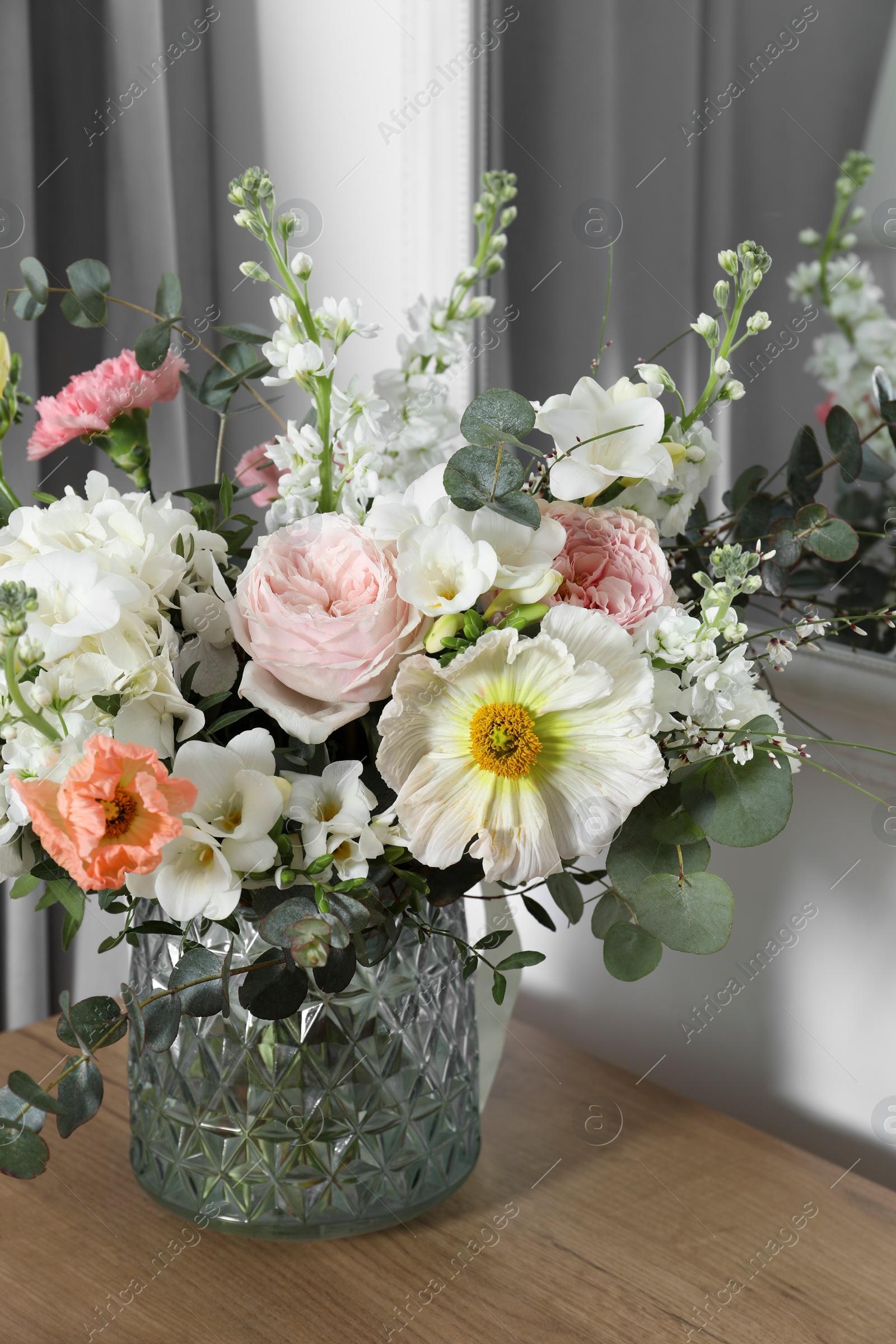 Photo of Bouquet of beautiful flowers on wooden table indoors