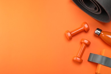 Photo of Dumbbells, yoga block, mat, thermo bottle and fitness elastic band on orange background, flat lay. Space for text