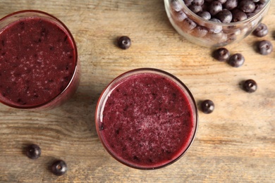 Glasses with delicious acai smoothie on wooden table, top view