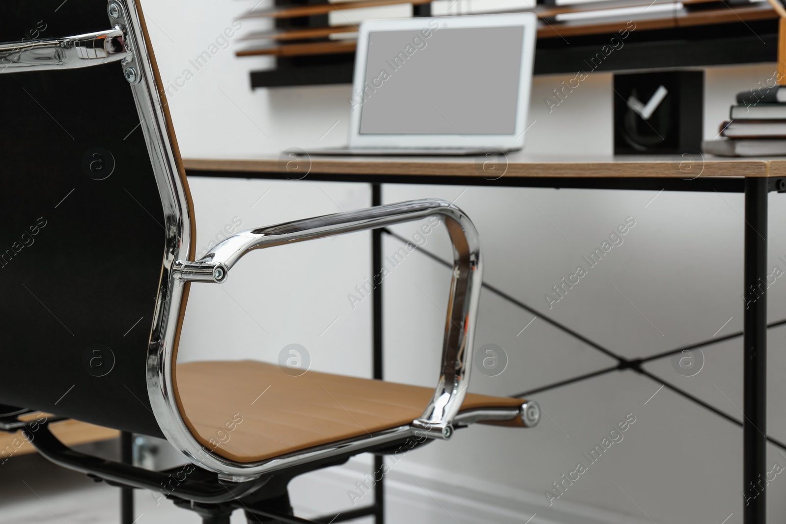 Photo of Stylish workplace interior with modern office chair