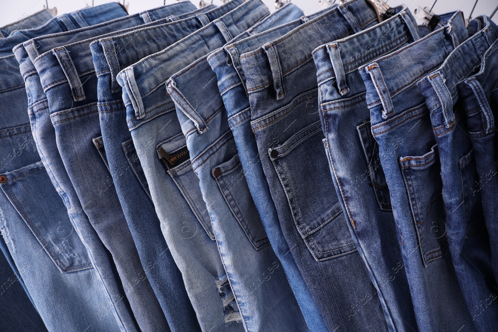 Photo of Closeup view of rack with different jeans