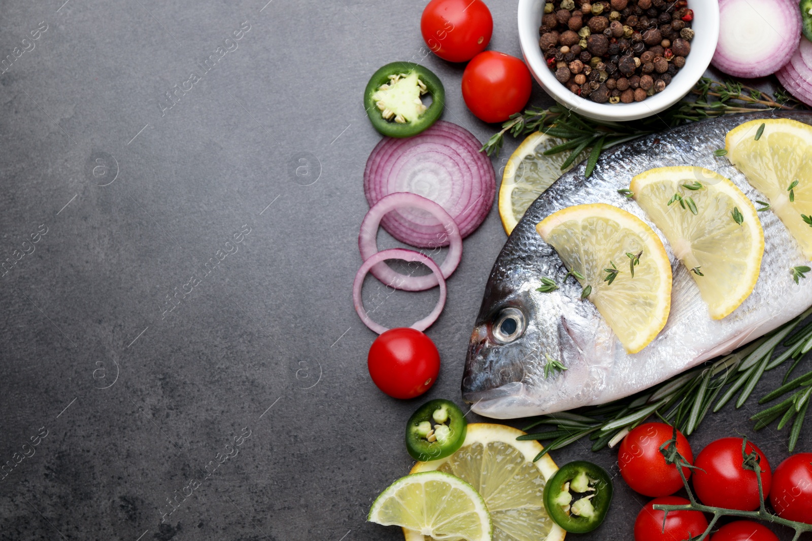 Photo of Fresh dorado fish and ingredients on black table, flat lay. Space for text