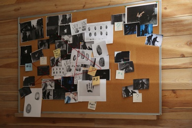 Photo of Detective board with crime scene photos, fingerprints, clues and red thread on wall