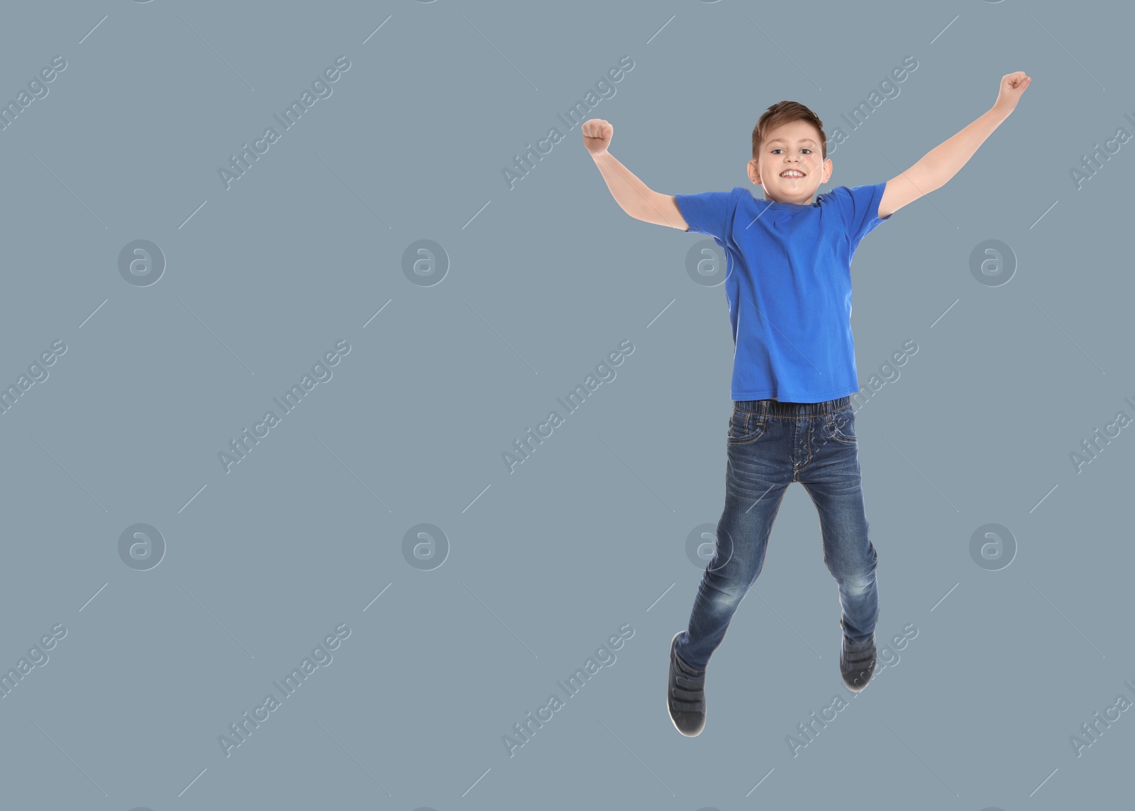 Image of Happy boy jumping on grey background, space for text