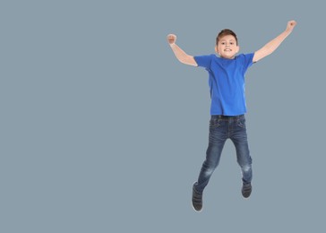 Image of Happy boy jumping on grey background, space for text