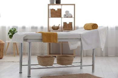 Comfortable massage table with clean towels in spa center