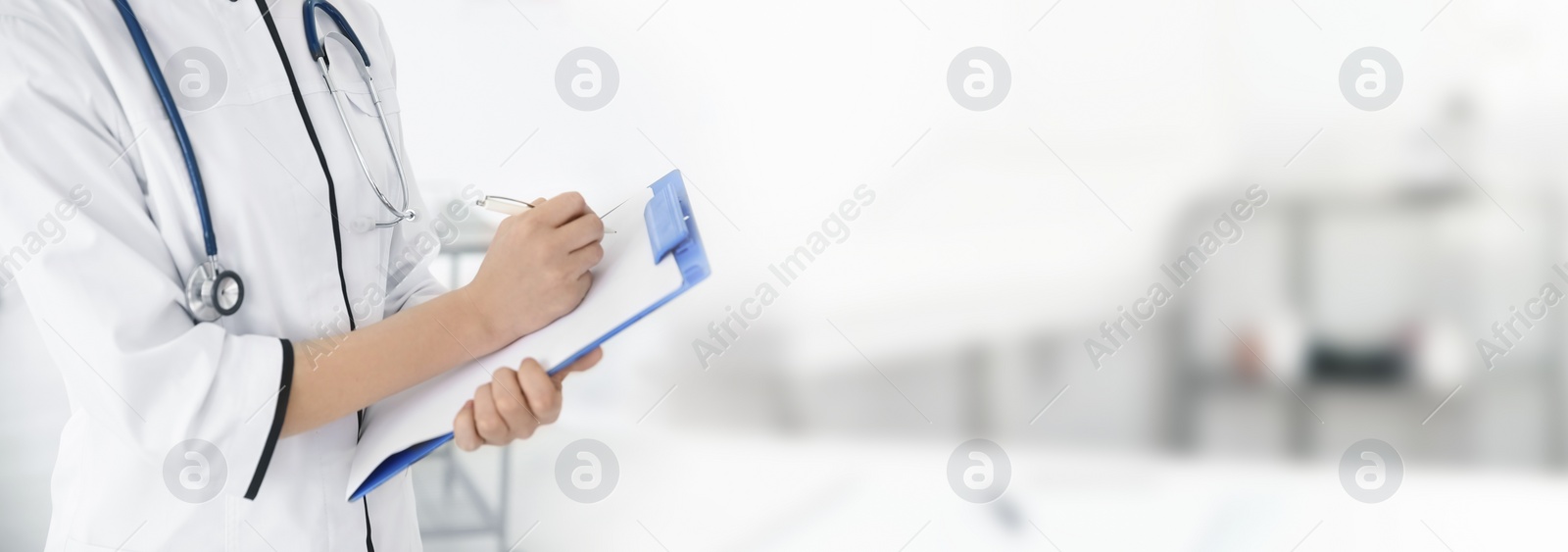 Image of Young doctor with clipboard in hospital, space for text. Health care worker