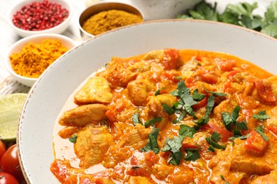 Photo of Delicious chicken curry and ingredients on table, closeup