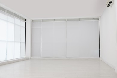 Photo of Empty room with white wall and laminated flooring