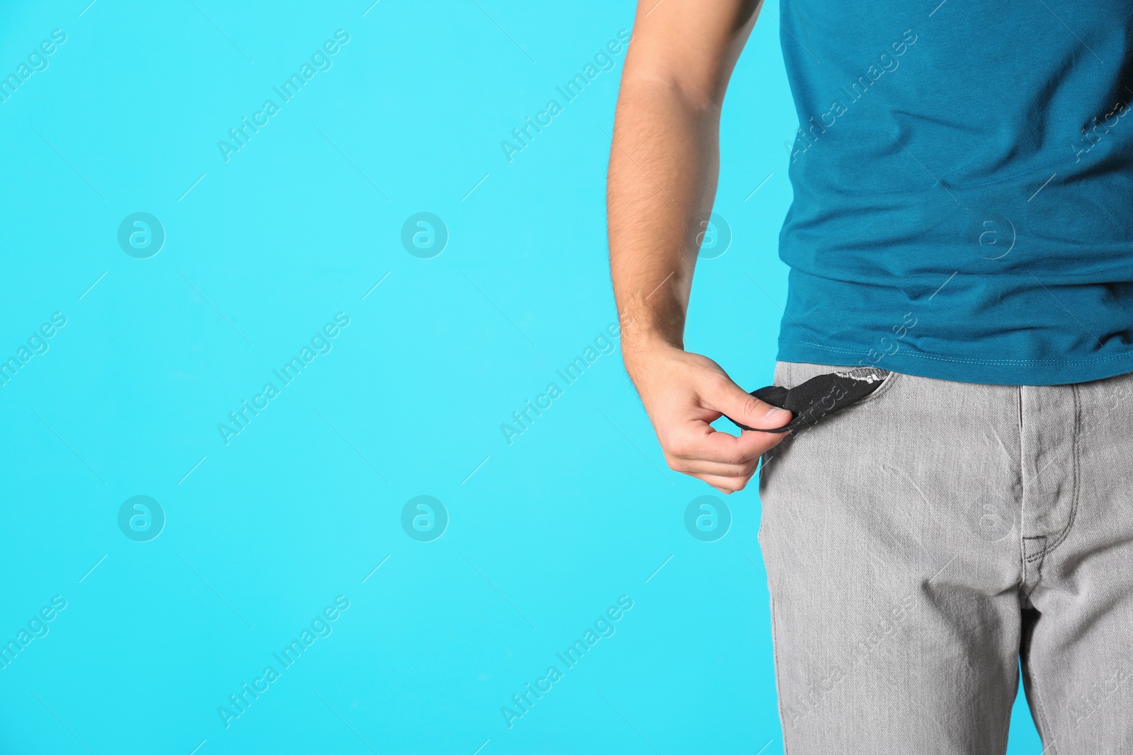 Photo of Man showing empty pocket on color background, closeup. Space for text