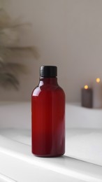 Photo of Red bottle of bubble bath on tub indoors