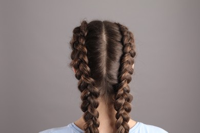 Photo of Woman with braided hair on grey background, back view