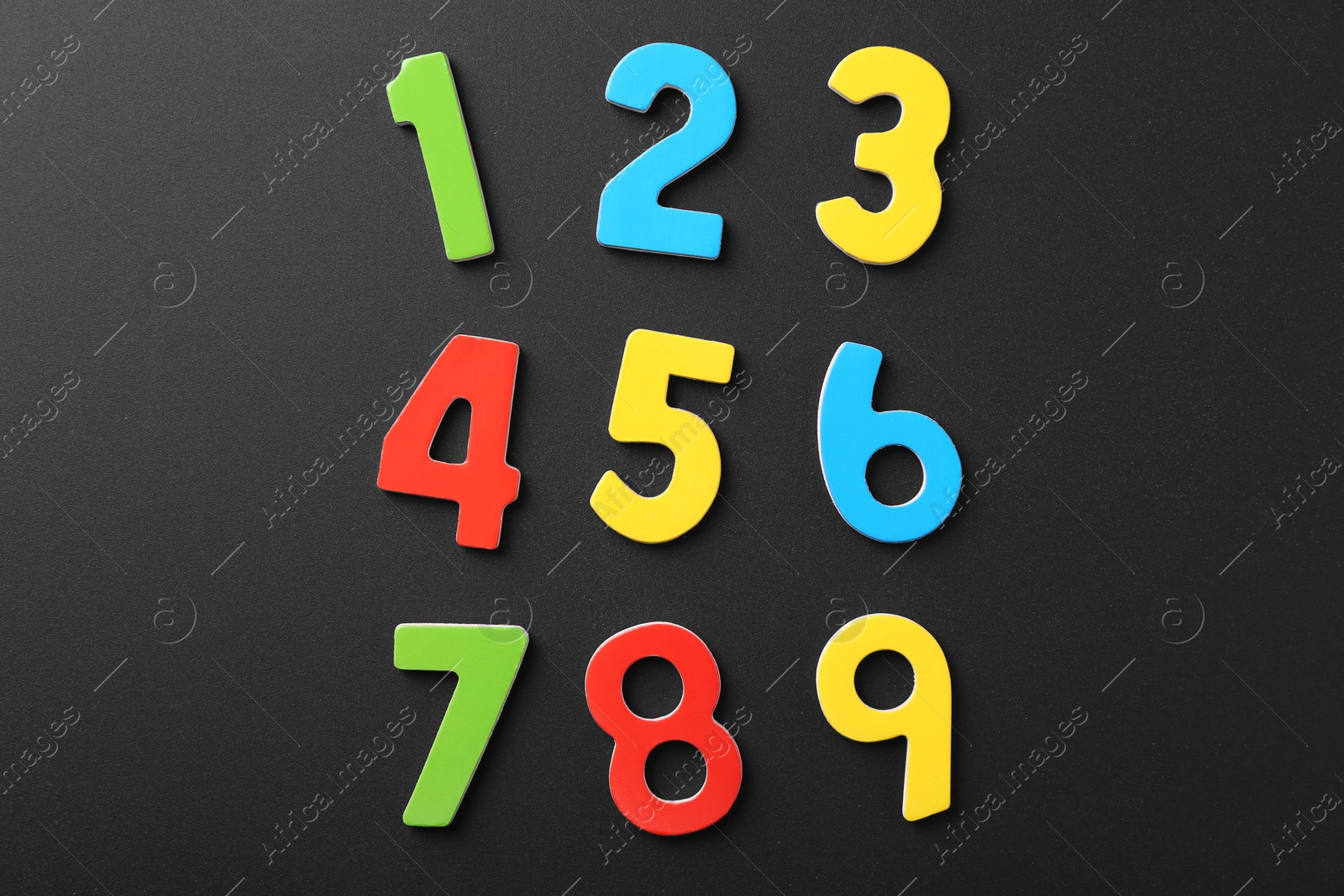 Photo of Colorful numbers on black background, flat lay