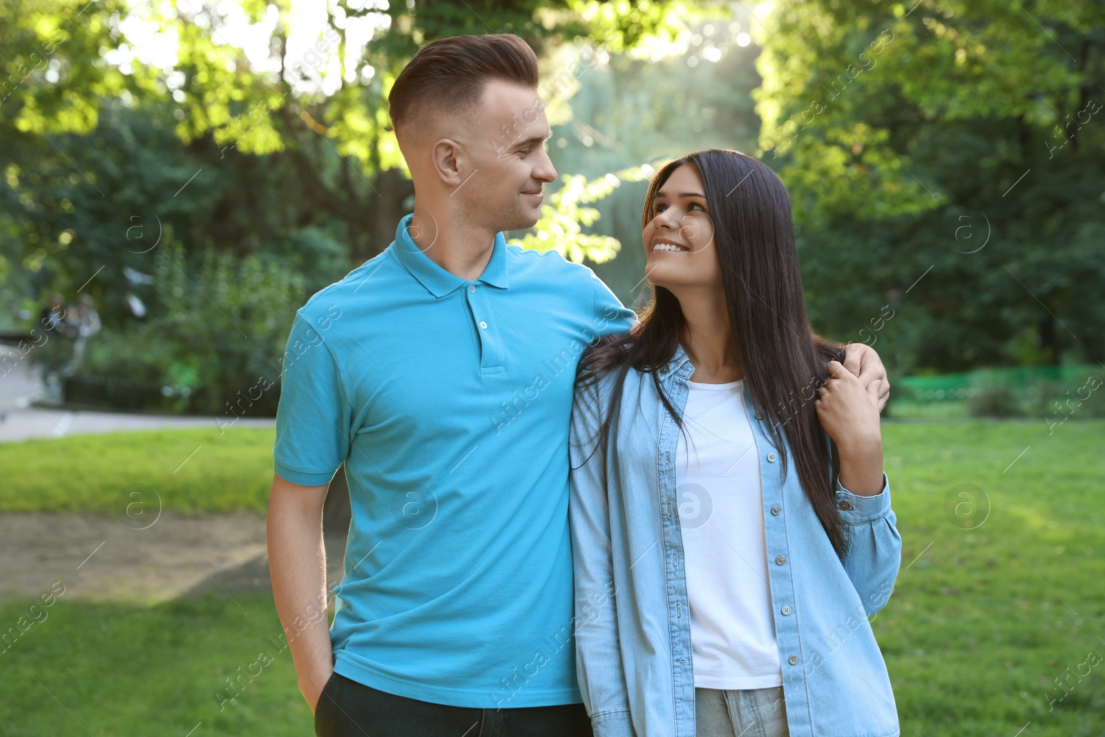 Photo of Affectionate happy young couple walking in park