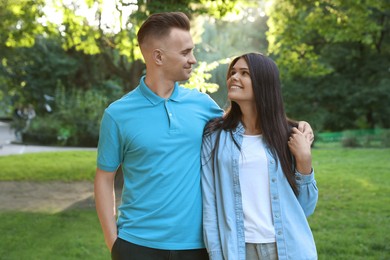 Affectionate happy young couple walking in park