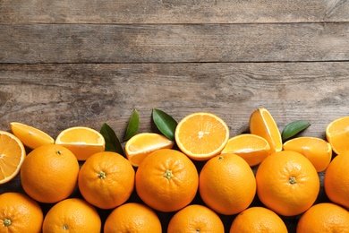 Flat lay composition with ripe oranges and space for text on wooden background