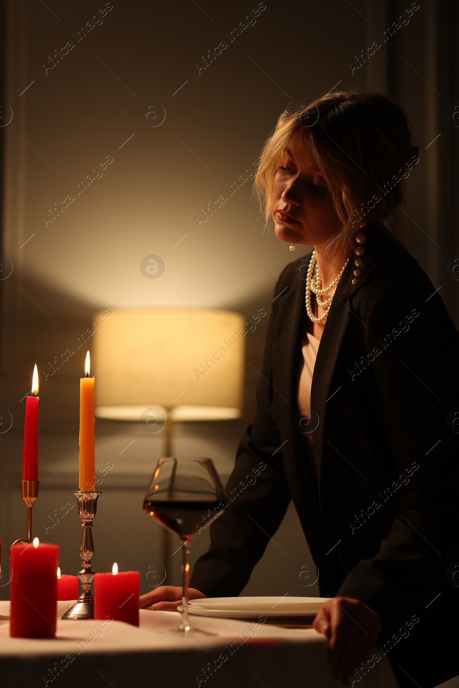 Photo of Beautiful young woman with glass of wine at table in restaurant