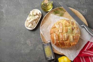 Photo of Freshly baked bread with tofu cheese served on grey table, flat lay. Space for text