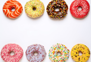 Photo of Delicious glazed donuts on white background, flat lay. Space for text