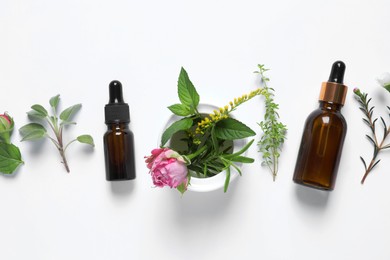 Photo of Bottles of essential oils, different herbs, rose flower and bud on white background, flat lay