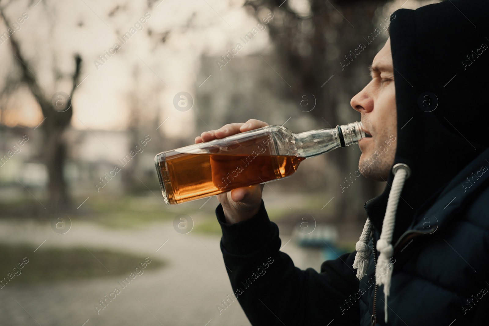 Photo of Addicted man drinking alcohol outdoors, closeup view