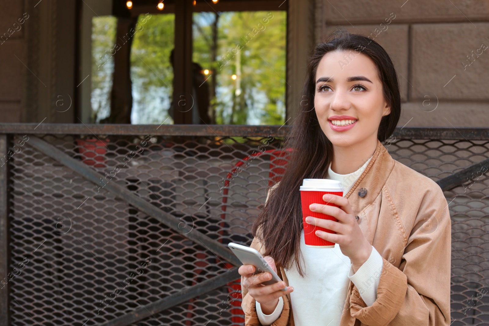 Photo of Young woman using mobile phone outdoors