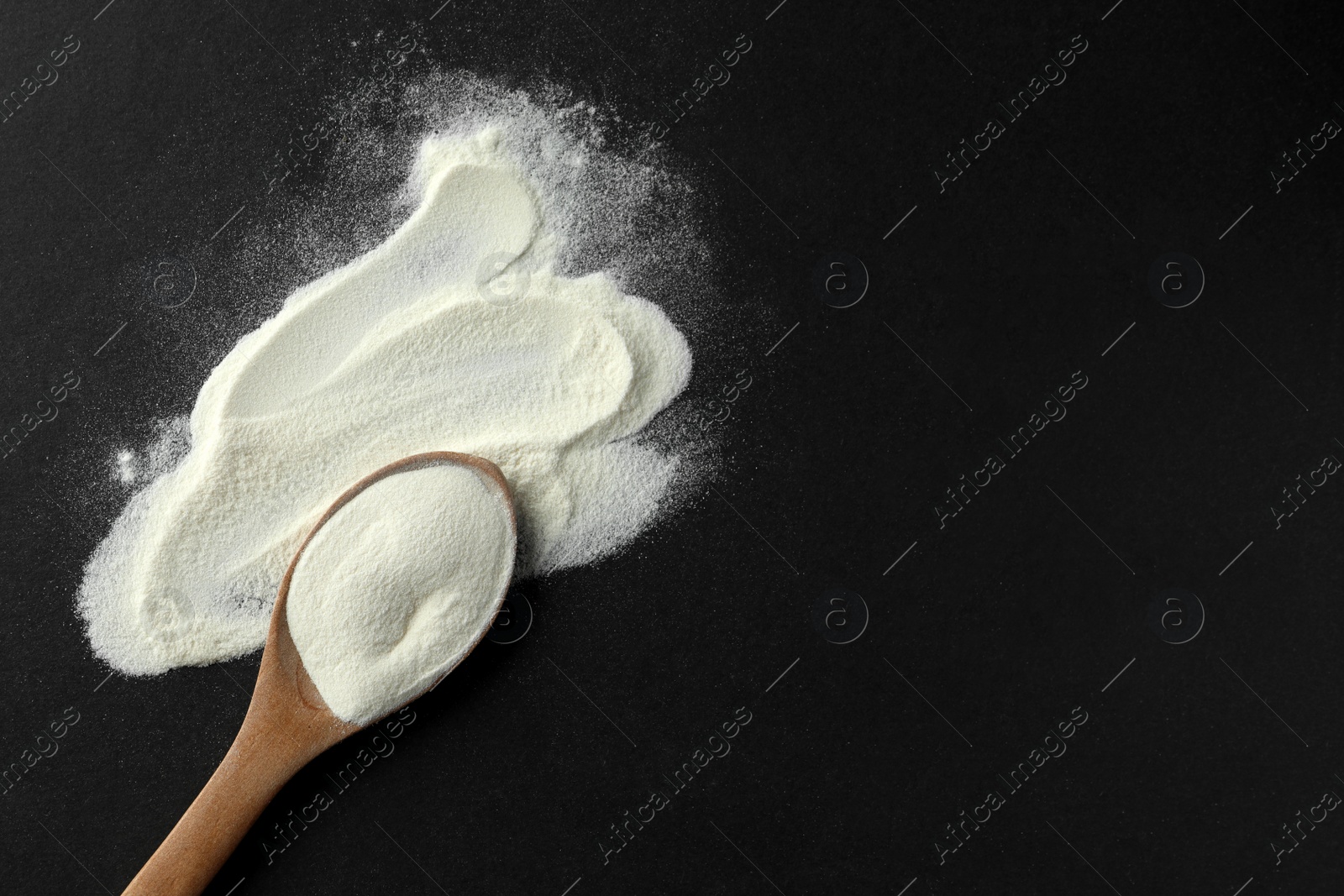 Photo of Spoon of agar-agar powder on black background, flat lay. Space for text