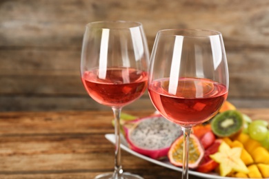 Delicious exotic fruits and wine on wooden table