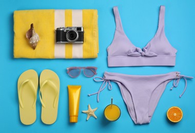 Photo of Flat lay composition with beach objects on light blue background