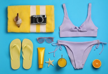 Flat lay composition with beach objects on light blue background