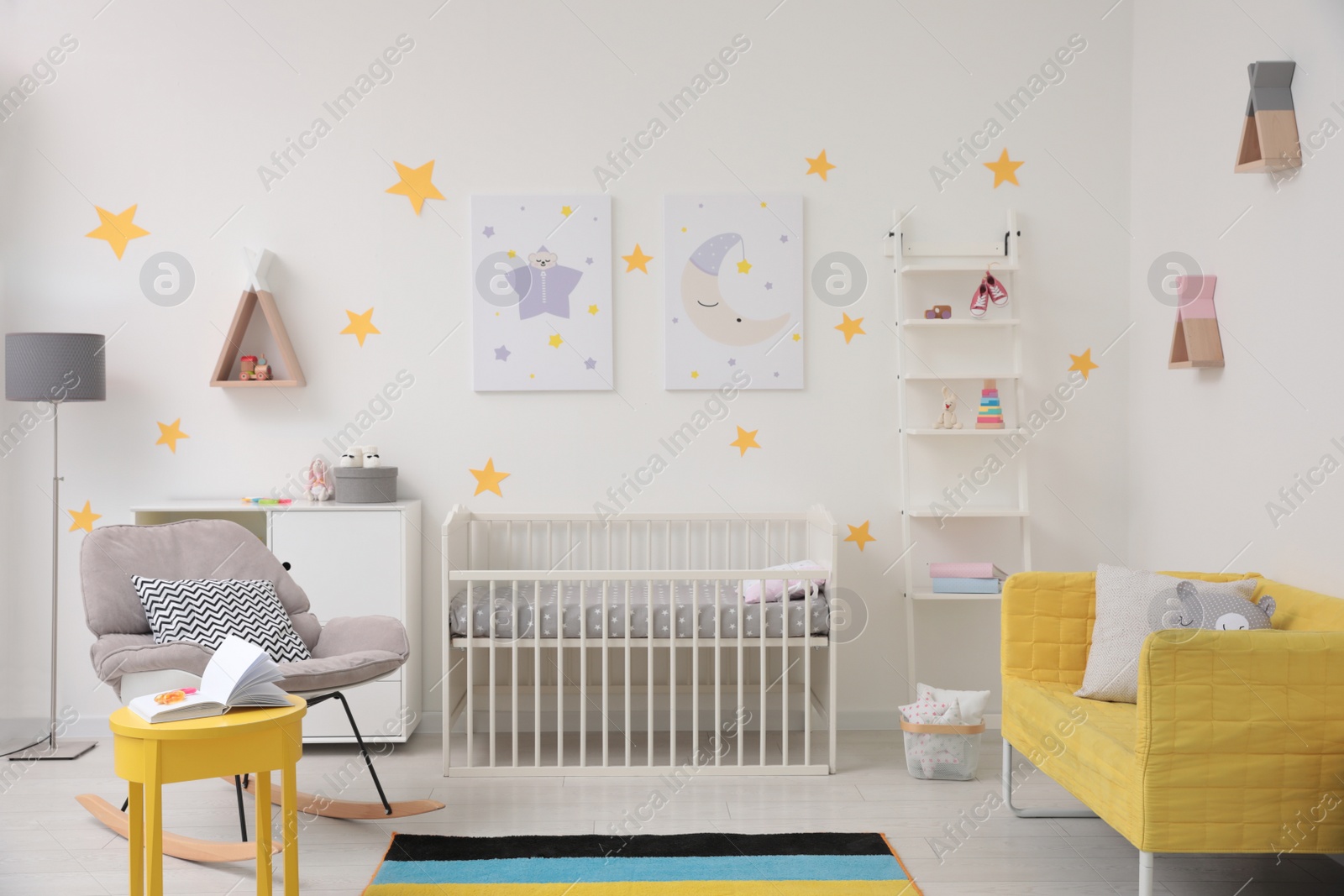 Photo of Stylish baby room interior with crib, rocking chair and sofa