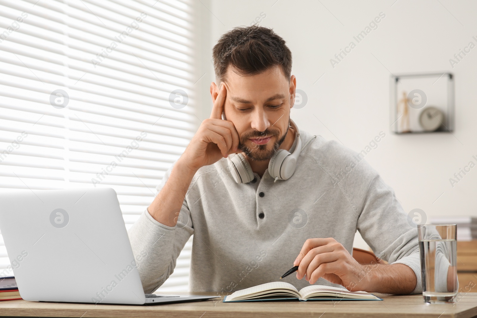 Photo of Man studying on laptop at home. Online translation course