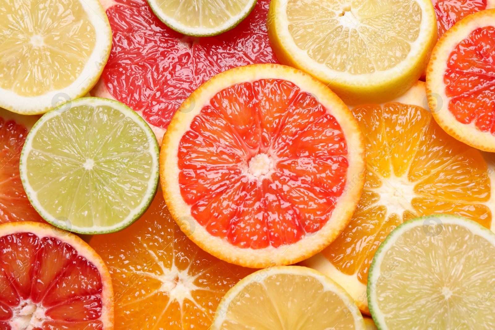 Photo of Fresh juicy citrus fruits as background, top view