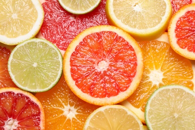 Photo of Fresh juicy citrus fruits as background, top view