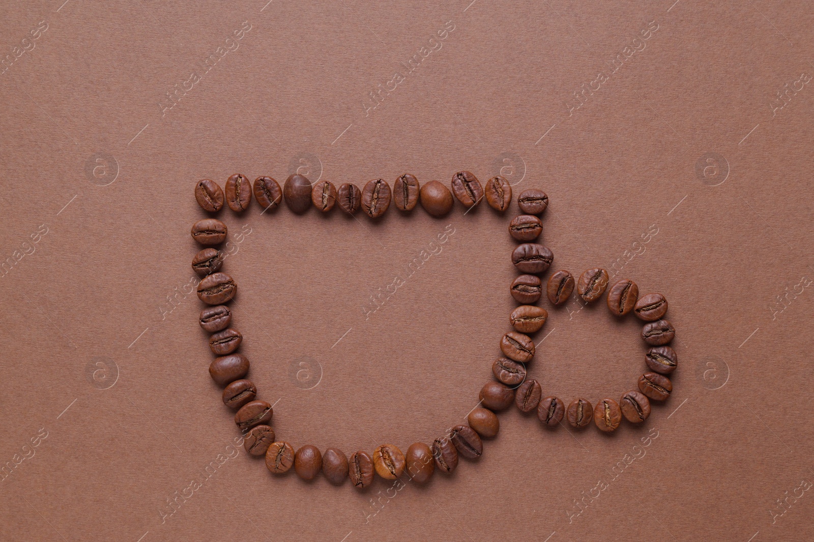 Photo of Cup of drink, composition made with coffee beans on brown background, flat lay