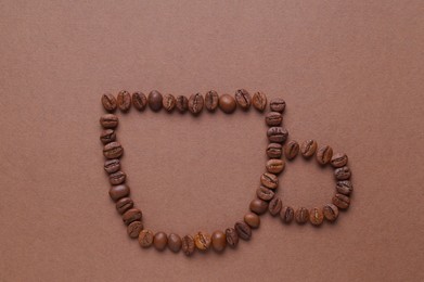 Photo of Cup of drink, composition made with coffee beans on brown background, flat lay