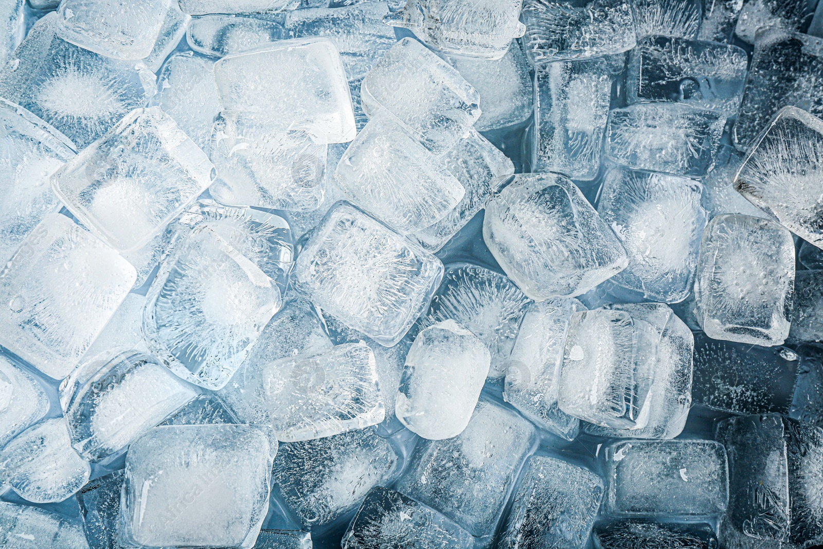 Photo of Crystal clear ice cubes as background, top view