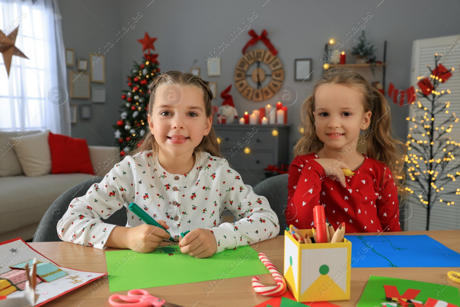 Photo of Cute little children making beautiful Christmas greeting cards at home