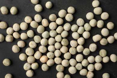 Raw dry peas on black background, flat lay. Vegetable seeds