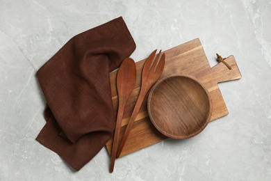Photo of Wooden cooking utensils on grey marble table, flat lay