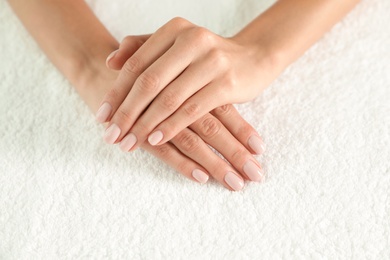 Woman with smooth hands and manicure on towel, closeup. Spa treatment