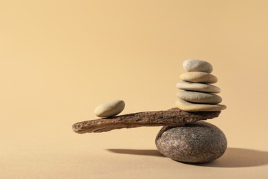 Photo of Stones with tree branch on beige background. Harmony and balance concept
