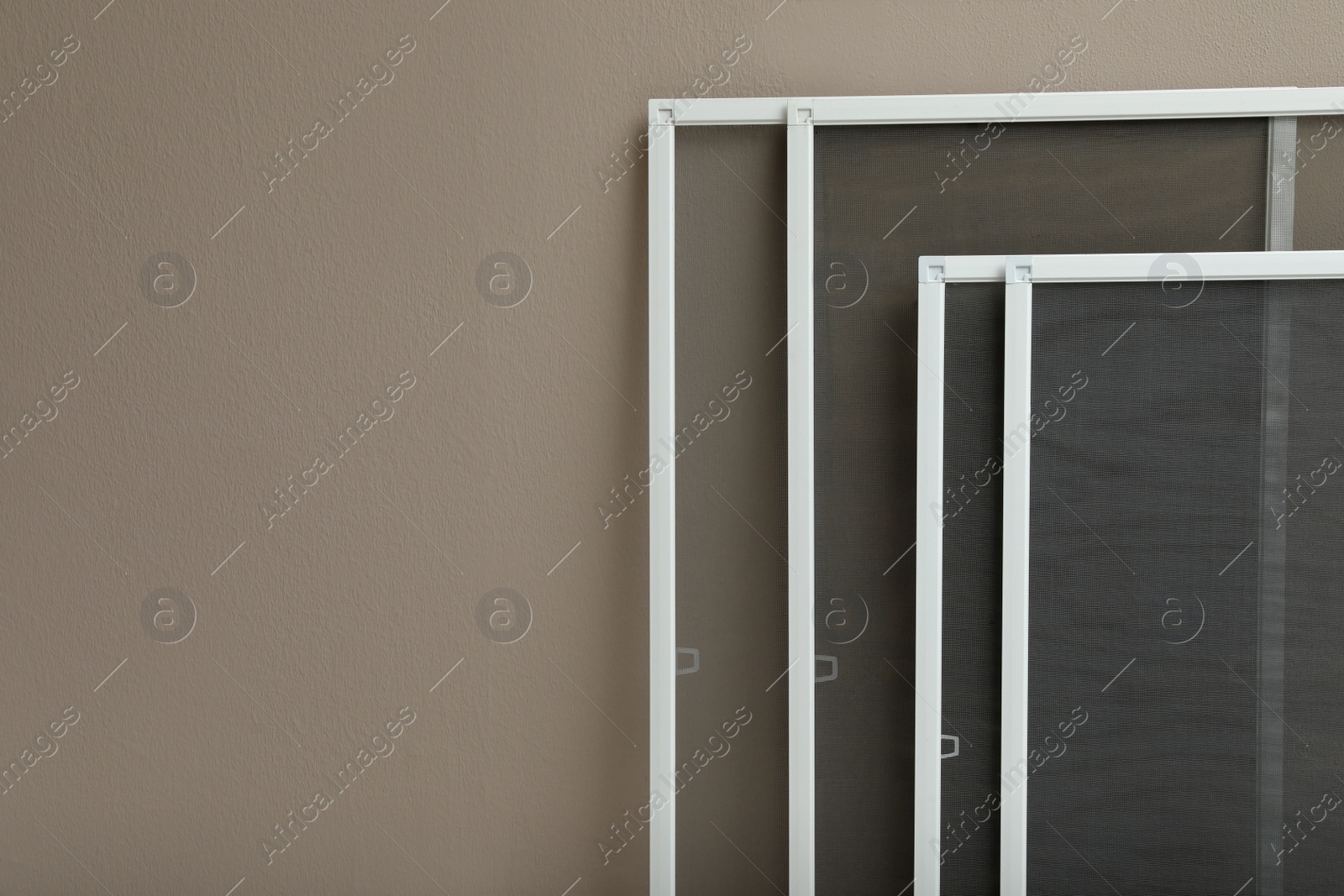 Photo of Set of window screens near beige wall. Space for text