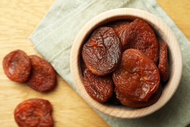 Bowl of tasty apricots on wooden table, top view and space for text. Dried fruits