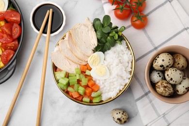 Delicious poke bowl of meat, egg, rice and vegetables served with soy sauce on white marble table, flat lay