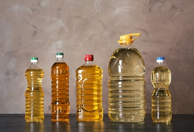 Bottles of oil on table against color background