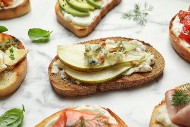 Photo of Many different tasty bruschettas on marble table