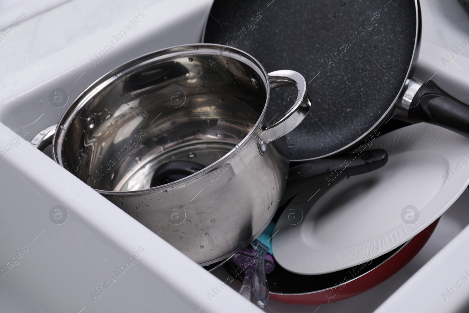 Photo of Many different clean dishes in sink, closeup