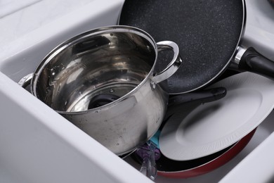 Many different clean dishes in sink, closeup