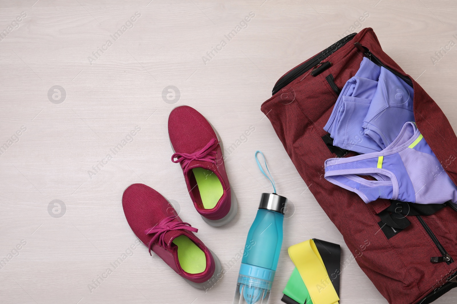 Photo of Gym bag and sports equipment on wooden background, flat lay. Space for text